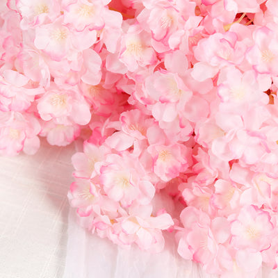 Pink artificial flower bouquet on a soft white background.