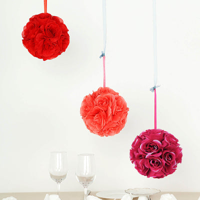 Hanging floral decorations in red, pink, and purple on a white backdrop
