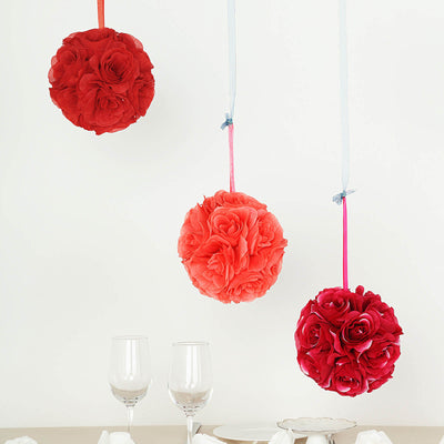 Hanging floral pom poms in red and pink with glassware below