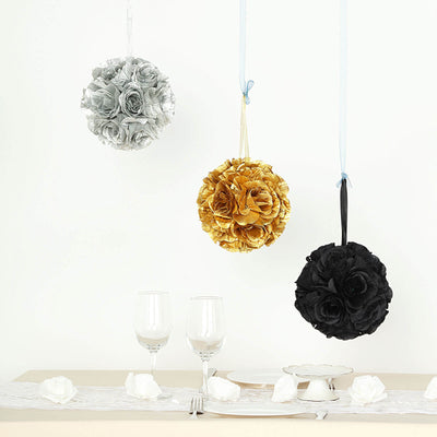 Hanging decorative floral balls in silver, gold, and black above a table setting.