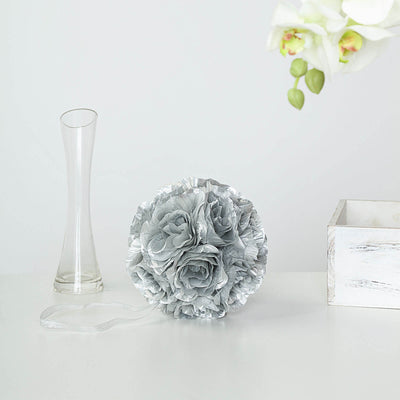 Silver floral arrangement with ribbon on a white table.