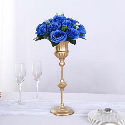 Gold vase with blue roses, elegant table decor for weddings or events.