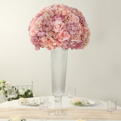 Pink floral centerpiece in a tall glass vase for elegant table decor.
