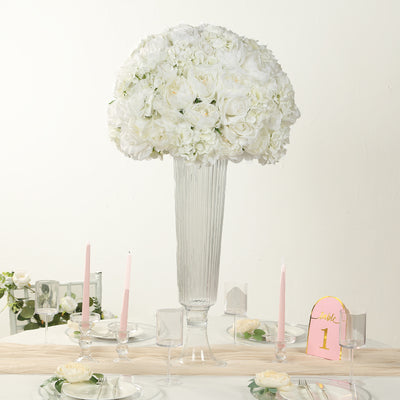 Elegant white floral centerpiece in a tall glass vase on a decorated table.