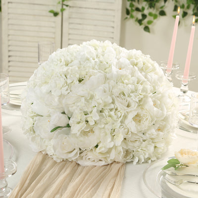 White floral centerpiece arrangement on a dining table.
