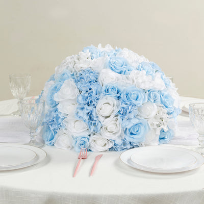 Blue and white floral centerpiece on a dining table with plates and glassware.