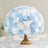 Blue and white floral centerpiece arrangement in a gold vase.