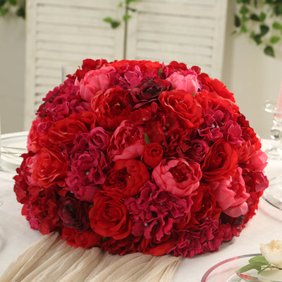 Red and pink floral centerpiece bouquet on a table.