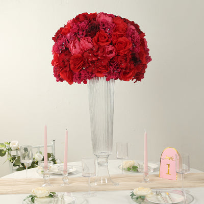 Elegant floral centerpiece with red roses and pink hydrangeas in a tall glass vase.