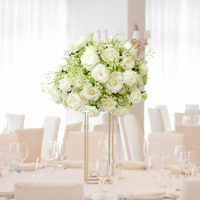 Elegant white floral centerpiece for wedding reception table decor.