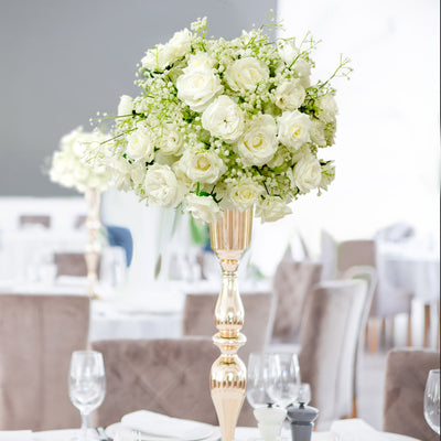 Elegant white floral centerpiece in a gold vase for table decoration.