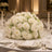 Elegant white floral wedding centerpiece with candles and gold table setting
