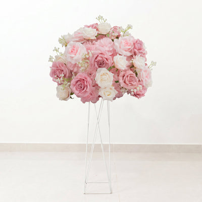 Pink and white rose floral arrangement on a tall stand in a white room