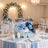 Elegant blue and white wedding reception table with floral centerpiece and candles