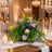 Elegant candlelit banquet table with pastel floral centerpiece and crystal chandeliers