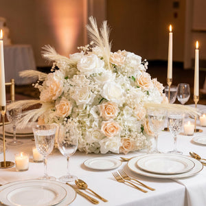Elegant white and blush floral centerpiece on a candlelit wedding reception table