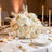 Elegant white and blush floral centerpiece on a candlelit wedding reception table