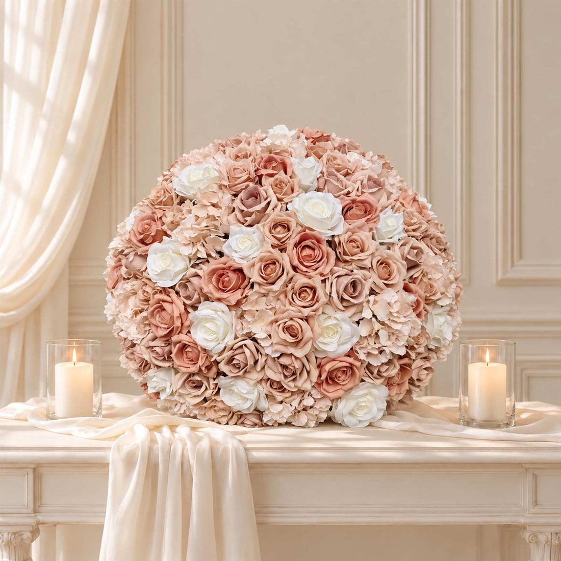 Elegant blush and white rose floral arrangement with candles on a table