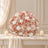 Elegant blush and white rose floral arrangement with candles on a table