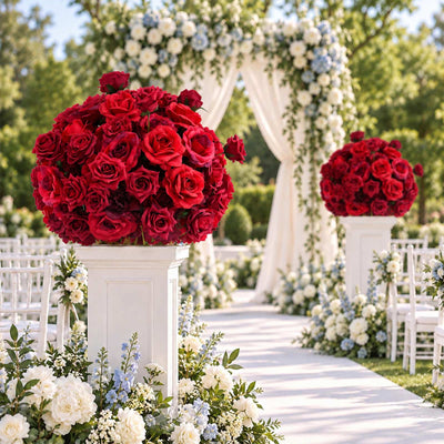 Outdoor wedding aisle with red rose floral arrangements and arch decor