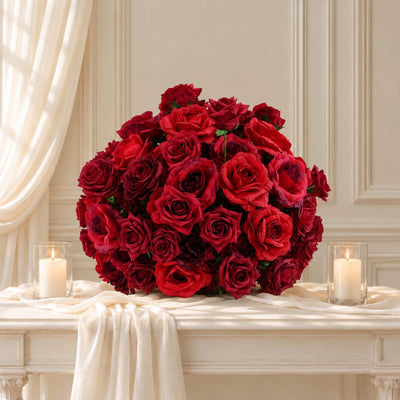 Elegant red rose bouquet centerpiece with candles on a white table