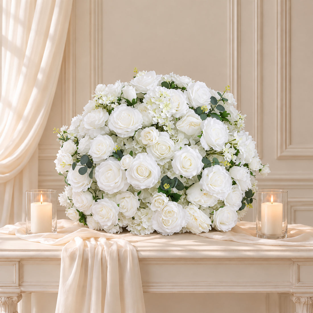 Elegant white floral centerpiece with candles on a draped table
