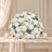 Elegant white floral centerpiece with candles on a draped table