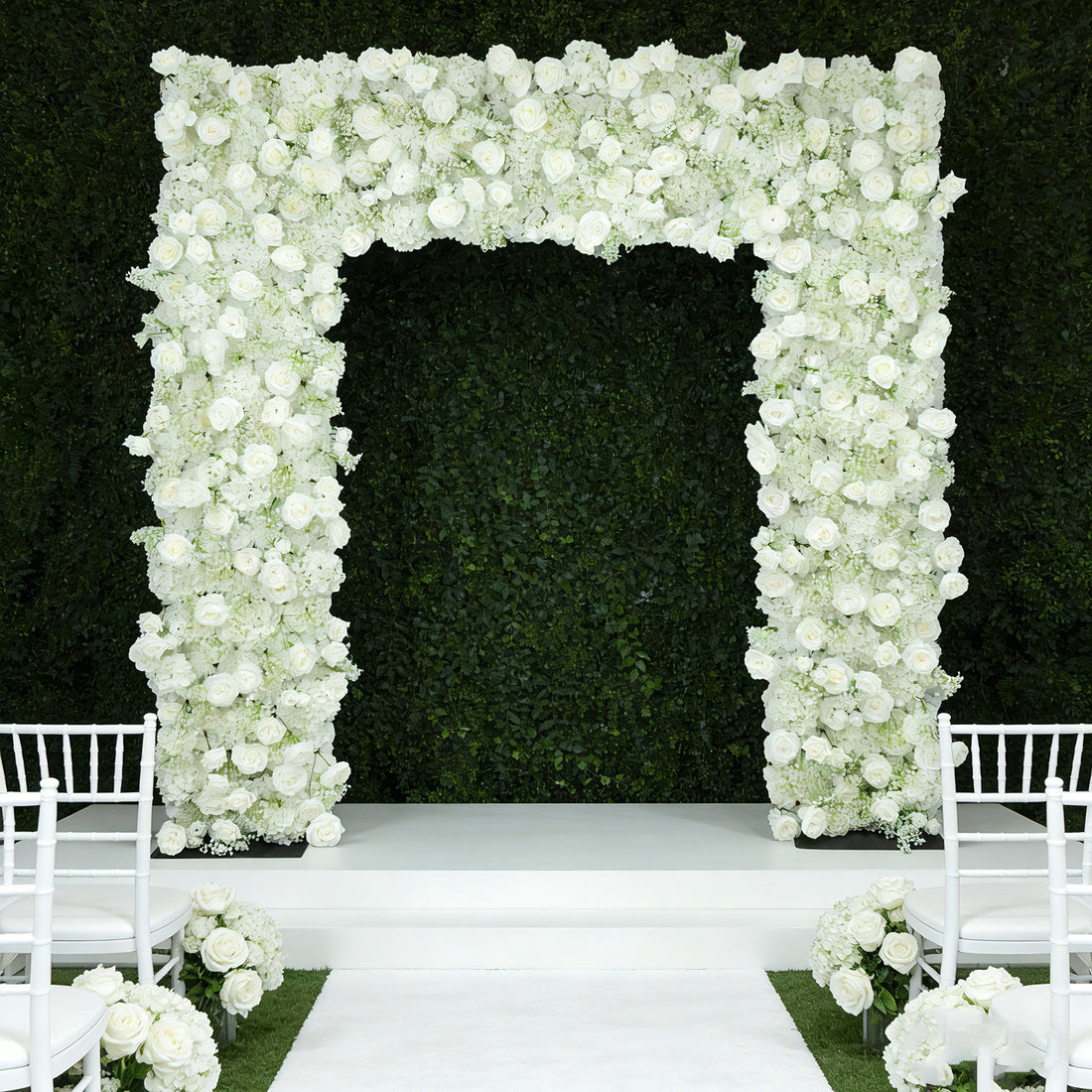 White floral archway for weddings or events on a green backdrop.