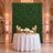 Elegant wedding reception backdrop with greenery wall, white roses, and gold candles