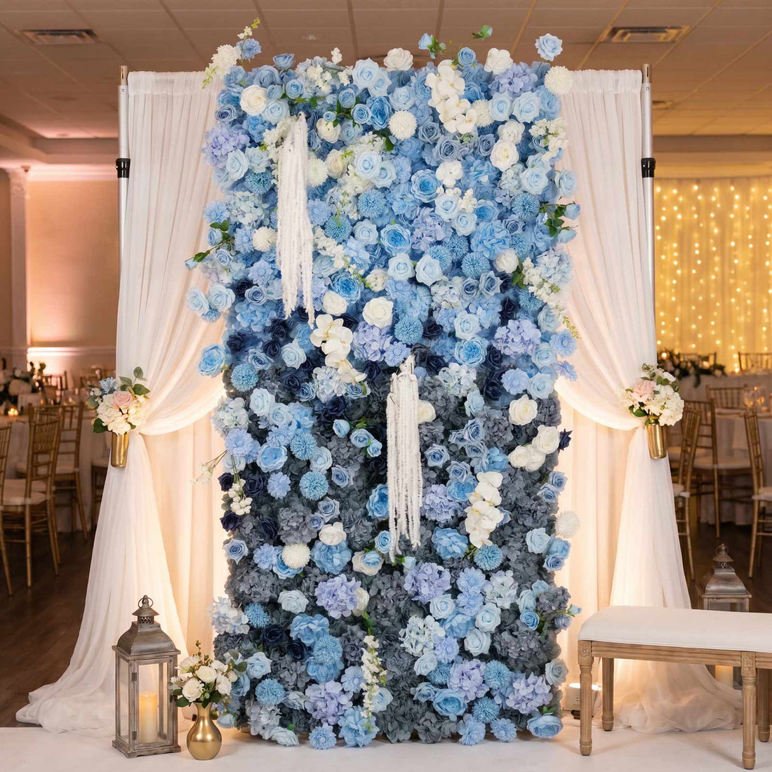 Blue floral wedding backdrop with white drapery and lantern decor