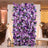 Lavender floral wedding backdrop with purple roses and draped white curtains
