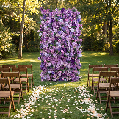 Outdoor wedding ceremony setup with purple floral arch and wooden chairs