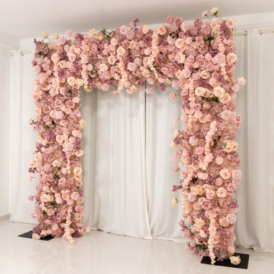 Floral archway with pink and cream flowers against a neutral backdrop.