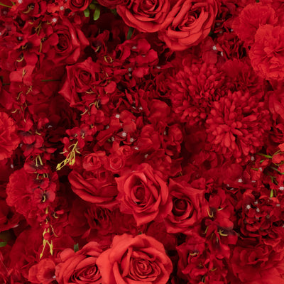 Red floral arrangement featuring roses, carnations, and chrysanthemums.