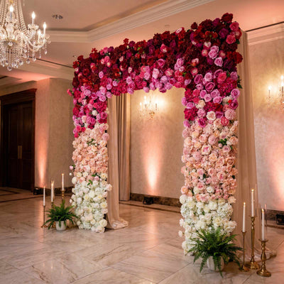 Luxury wedding floral arch with pink and white roses in an elegant ballroom