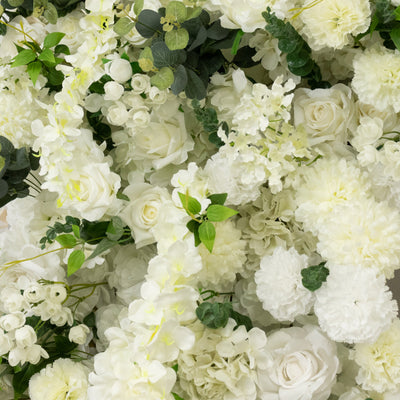 White floral arrangement with roses, orchids, and greenery
