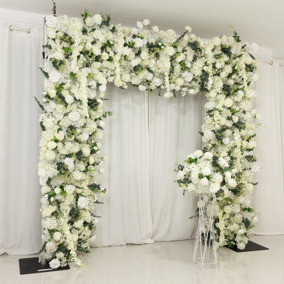 White floral arch with lush greenery, perfect for events and weddings.