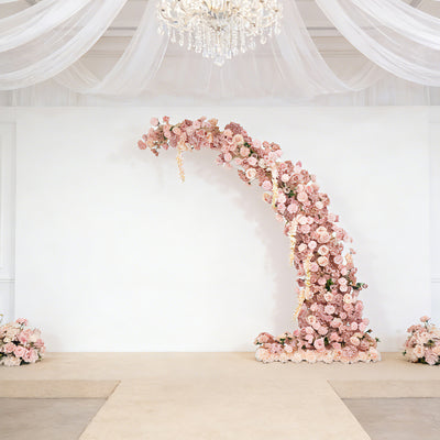 Floral wedding arch draped with pink flowers in elegant venue setting.