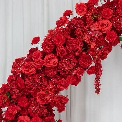 Vibrant red floral arrangement with roses and other blossoms against a white backdrop. #whtbkgd