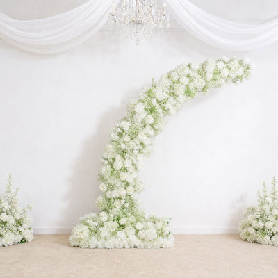 Elegant white floral wedding backdrop with chandelier and draped fabric