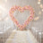 Pastel floral heart wedding arch with white aisle and chairs