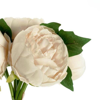 Artificial white peony bouquet with green leaves on a plain background