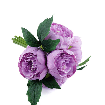 Purple peony floral bouquet with green leaves on a white background.