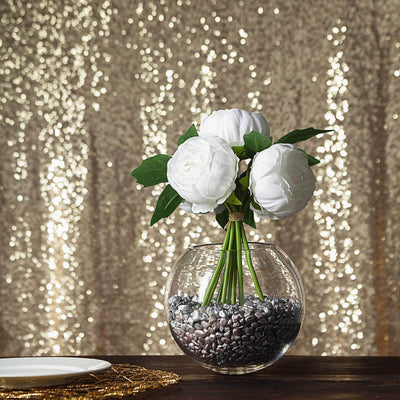 White flower bouquet in a glass vase with decorative stones.