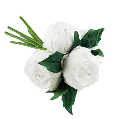 White peony flower bouquet with green leaves on a plain backdrop