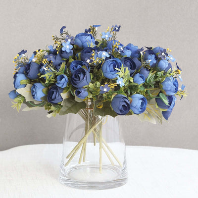 Blue artificial flower bouquet in a clear glass vase.