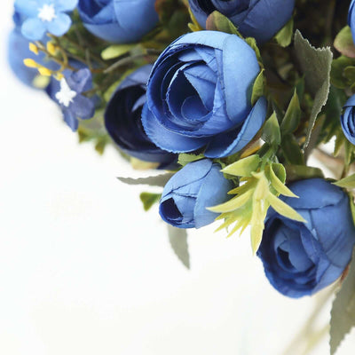 Blue artificial flower bouquet with green accents and foliage.