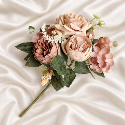 Artificial pastel peony bouquet on silk fabric background