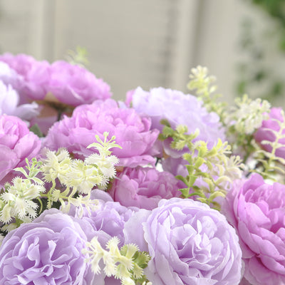 Colorful artificial flower bouquet in shades of purple and white.