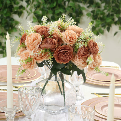 Elegant floral centerpiece with soft peach and brown roses in a glass vase.